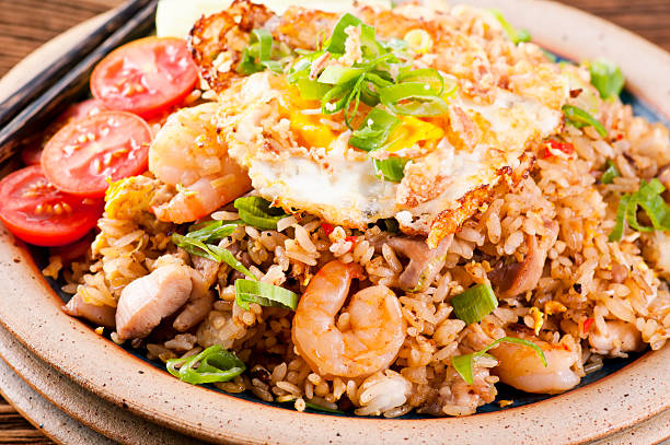 Nasi Goreng with fried egg, chicken and shrimp as closeup on a plate